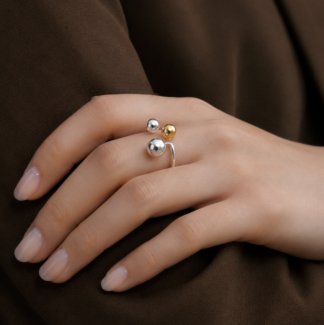Close-up of a hand wearing two rings on a brown background