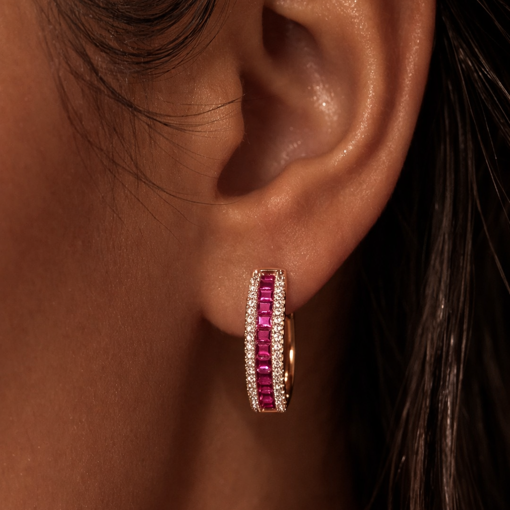 Close-up of an ear wearing a red gemstone earring with a dark background