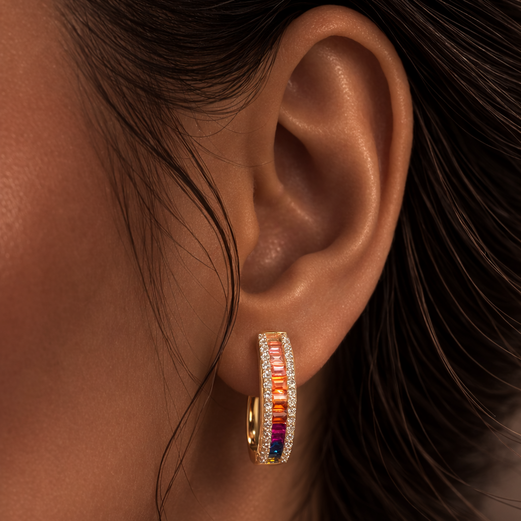 Close-up of an ear wearing a gold earring with colorful stones.