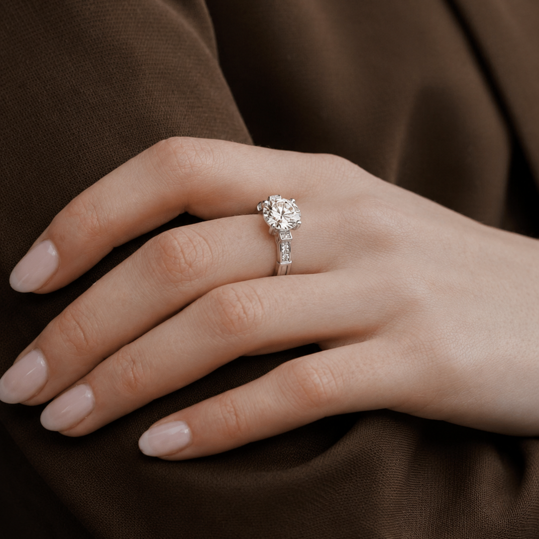 Close-up of a hand wearing a diamond ring on a brown fabric background