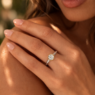 Close-up of a hand wearing a diamond ring with a blurred background