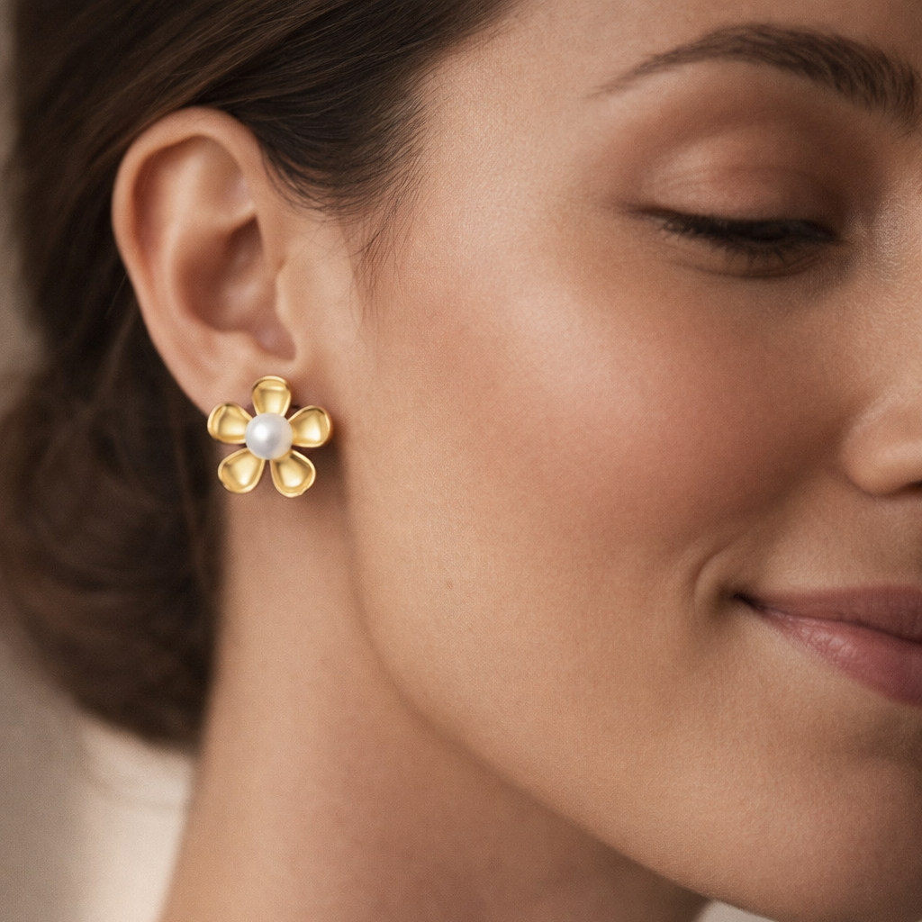 Close-up of a woman wearing gold flower-shaped earrings.