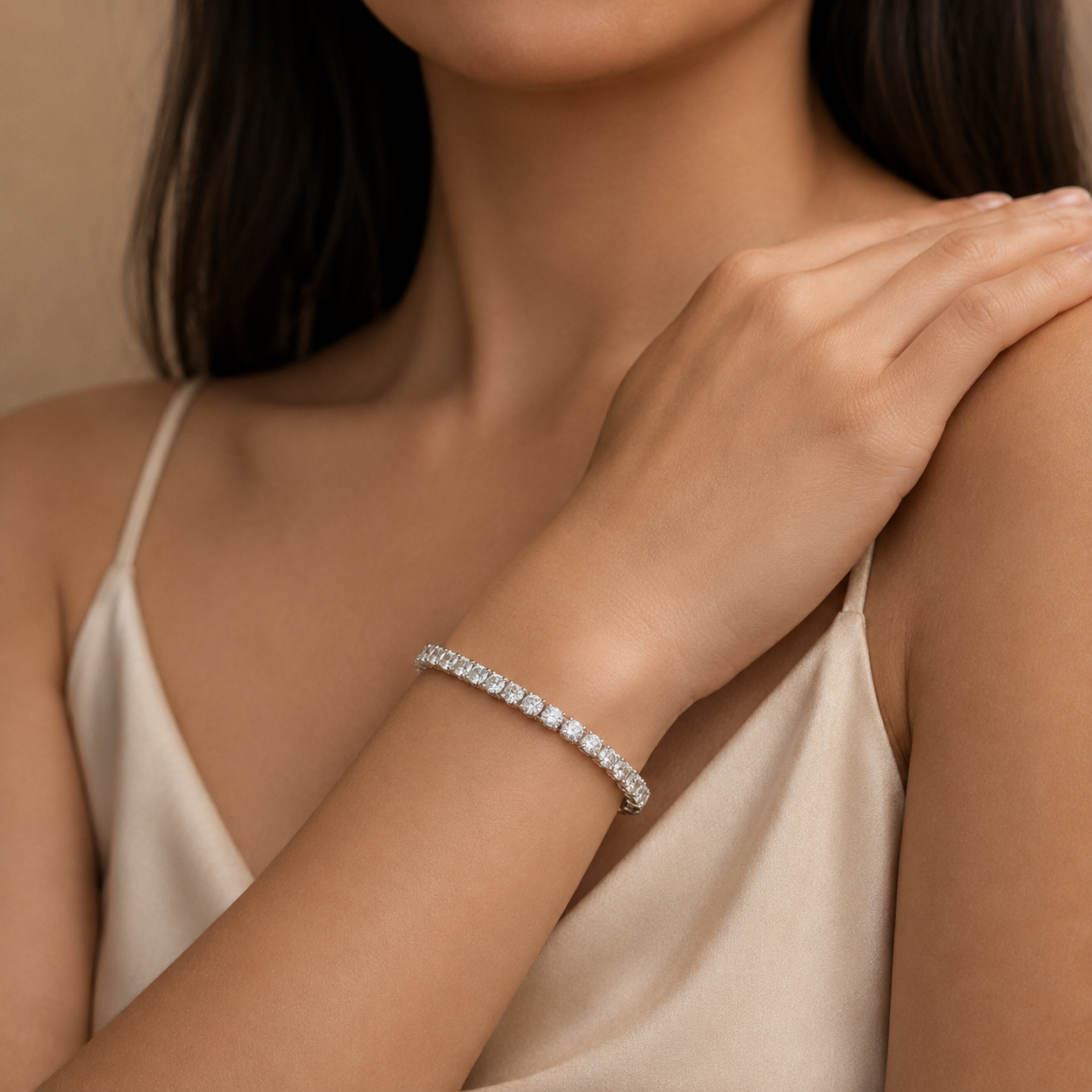 Woman wearing a diamond bracelet on a neutral background