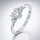 Silver ring with three diamonds and 'I LOVE YOU' engraving on a light gray background