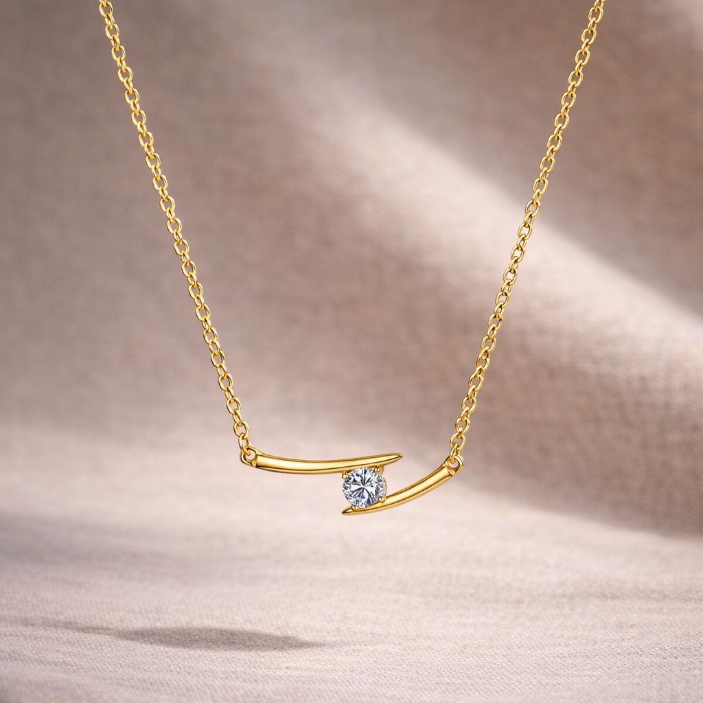 Gold necklace with a small blue gemstone on a beige fabric background