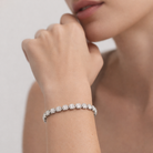 Close-up of a diamond bracelet on a person's wrist with a neutral background