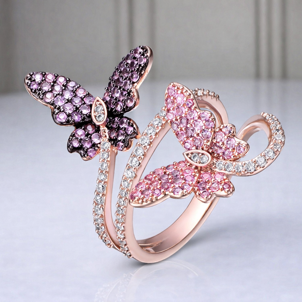 Butterfly-shaped rings with pink and purple gemstones on a light gray background