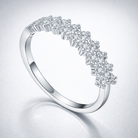 Silver ring with diamond accents on a light gray background