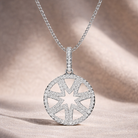 Silver necklace with a star-shaped pendant on a soft fabric background