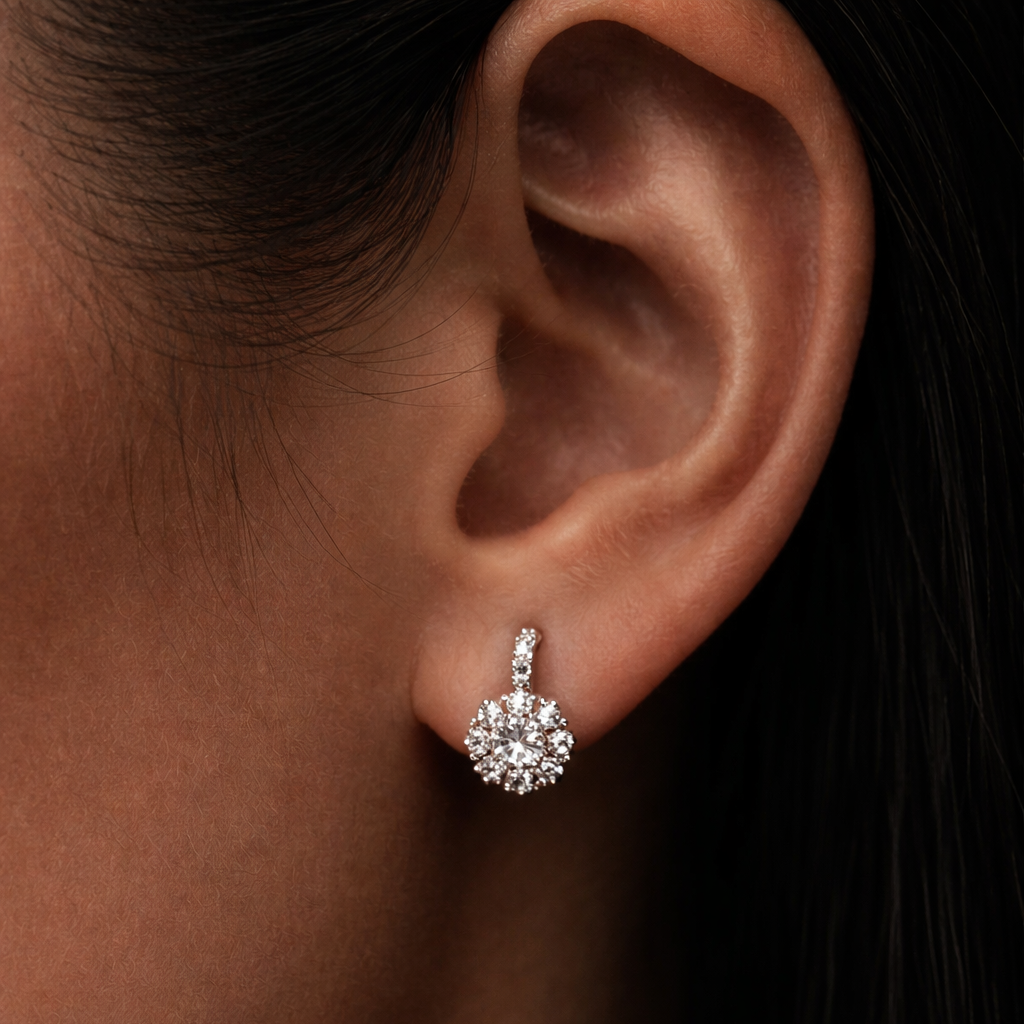 Close-up of an ear wearing a diamond earring with a dark background
