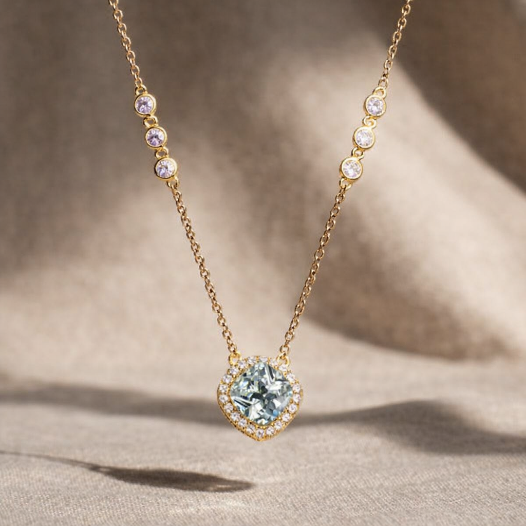 Delicate gold necklace with a heart-shaped gemstone pendant on a soft beige background