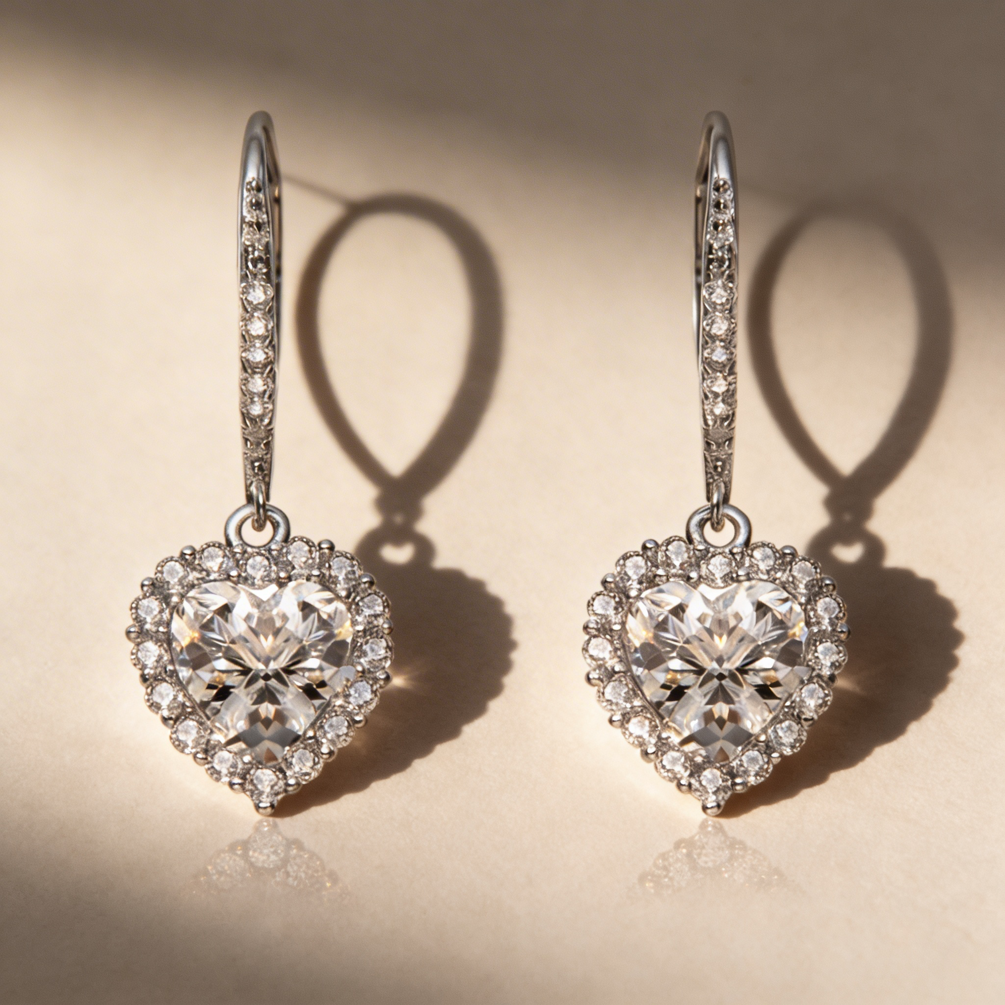 Heart-shaped diamond earrings on a beige background