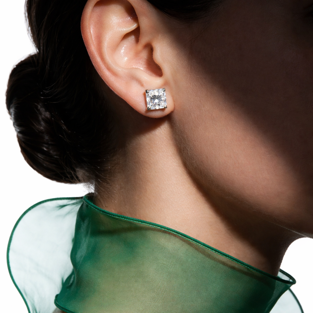 Close-up of a person wearing a diamond earring with a green sheer garment.
