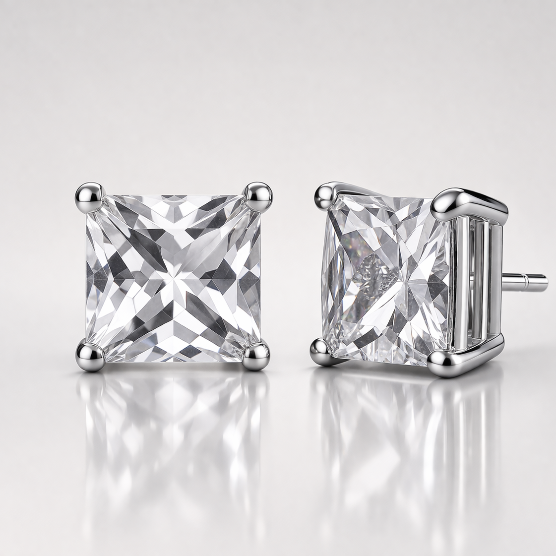 Pair of diamond stud earrings on a reflective surface with a light gray background