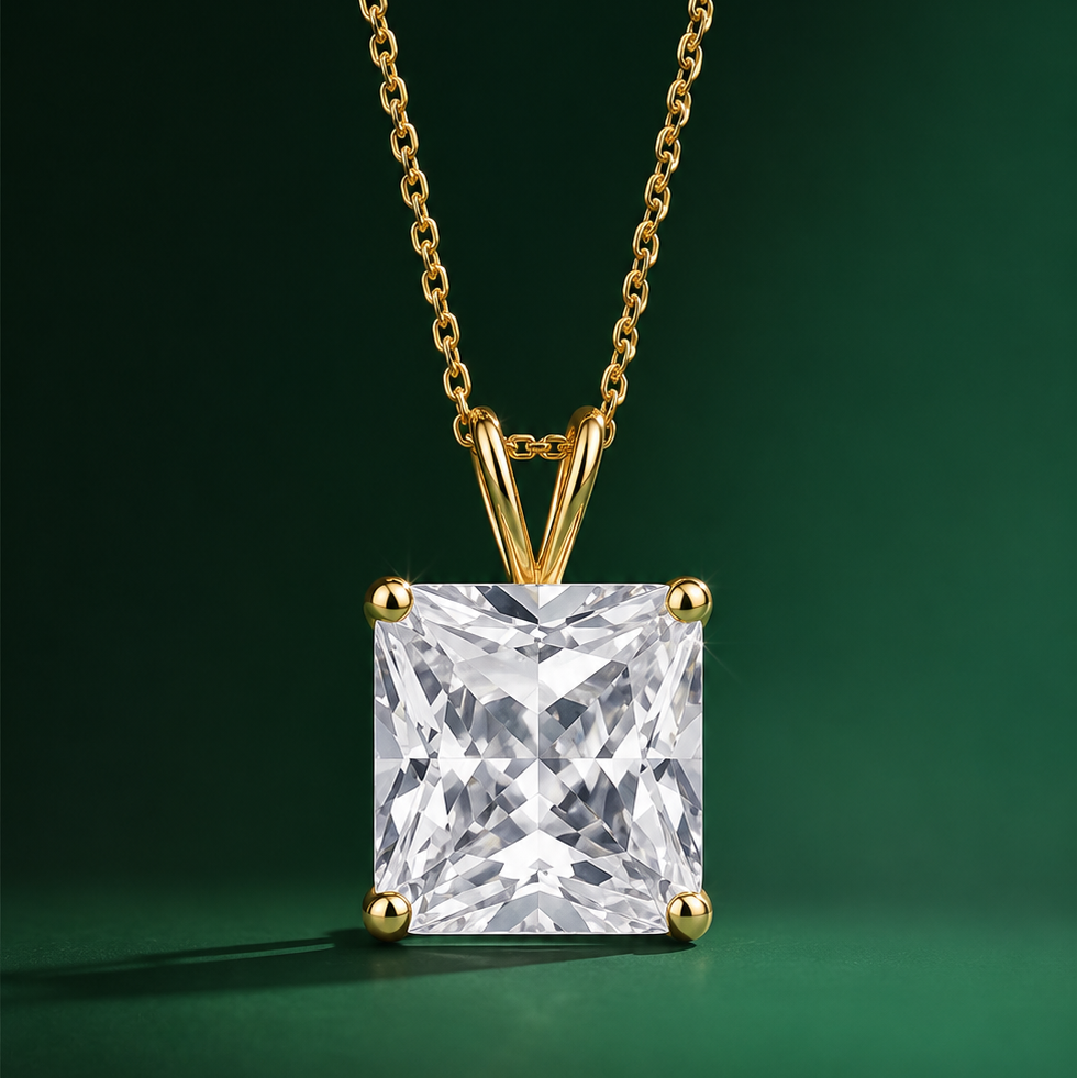 Gold necklace with a square-cut diamond pendant on a green background